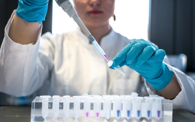 scientist using pipette with test tubes in lab - 5-Amino-1MQ research compound